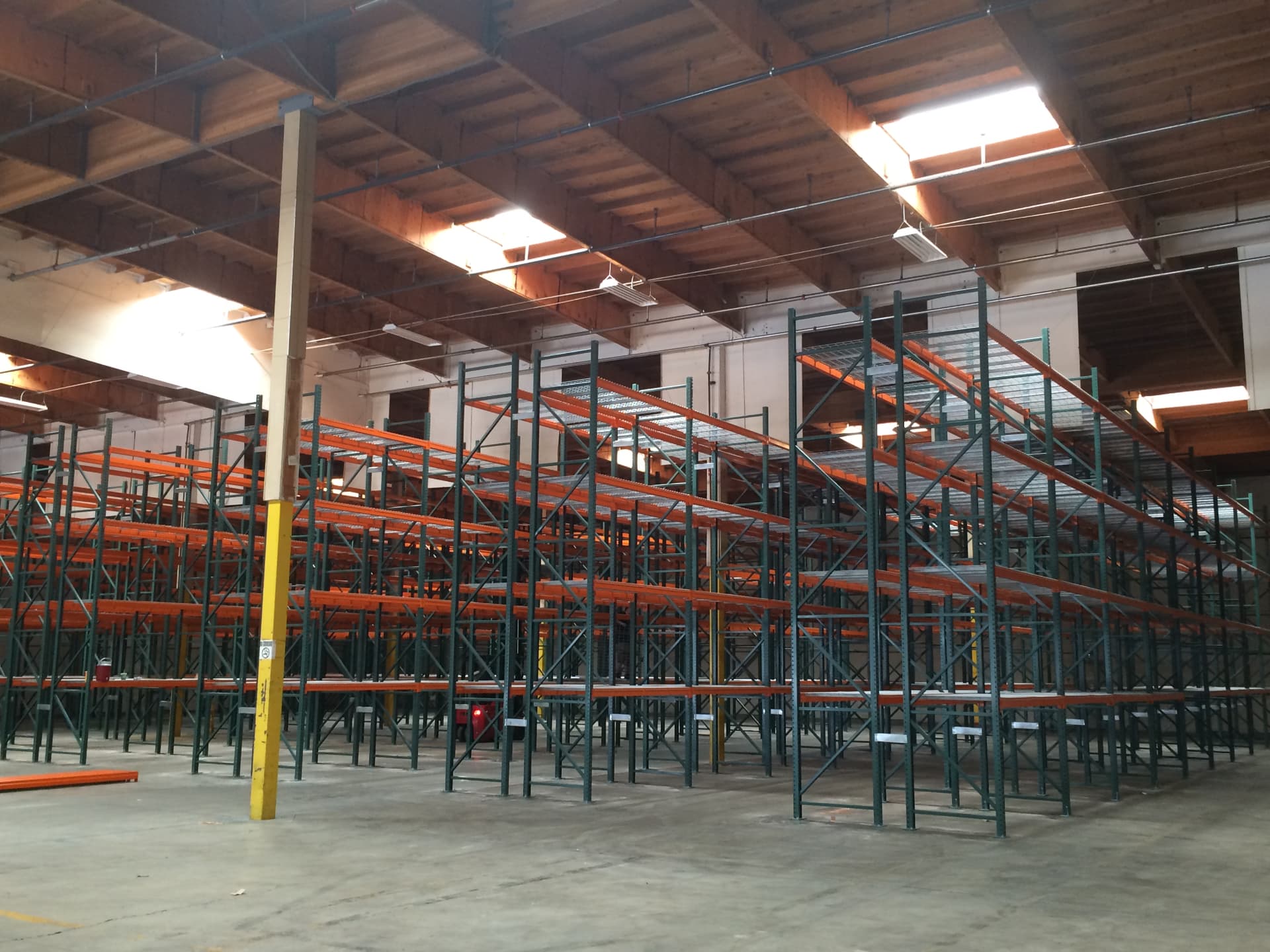 Rows of warehouse pallet racking under skylights